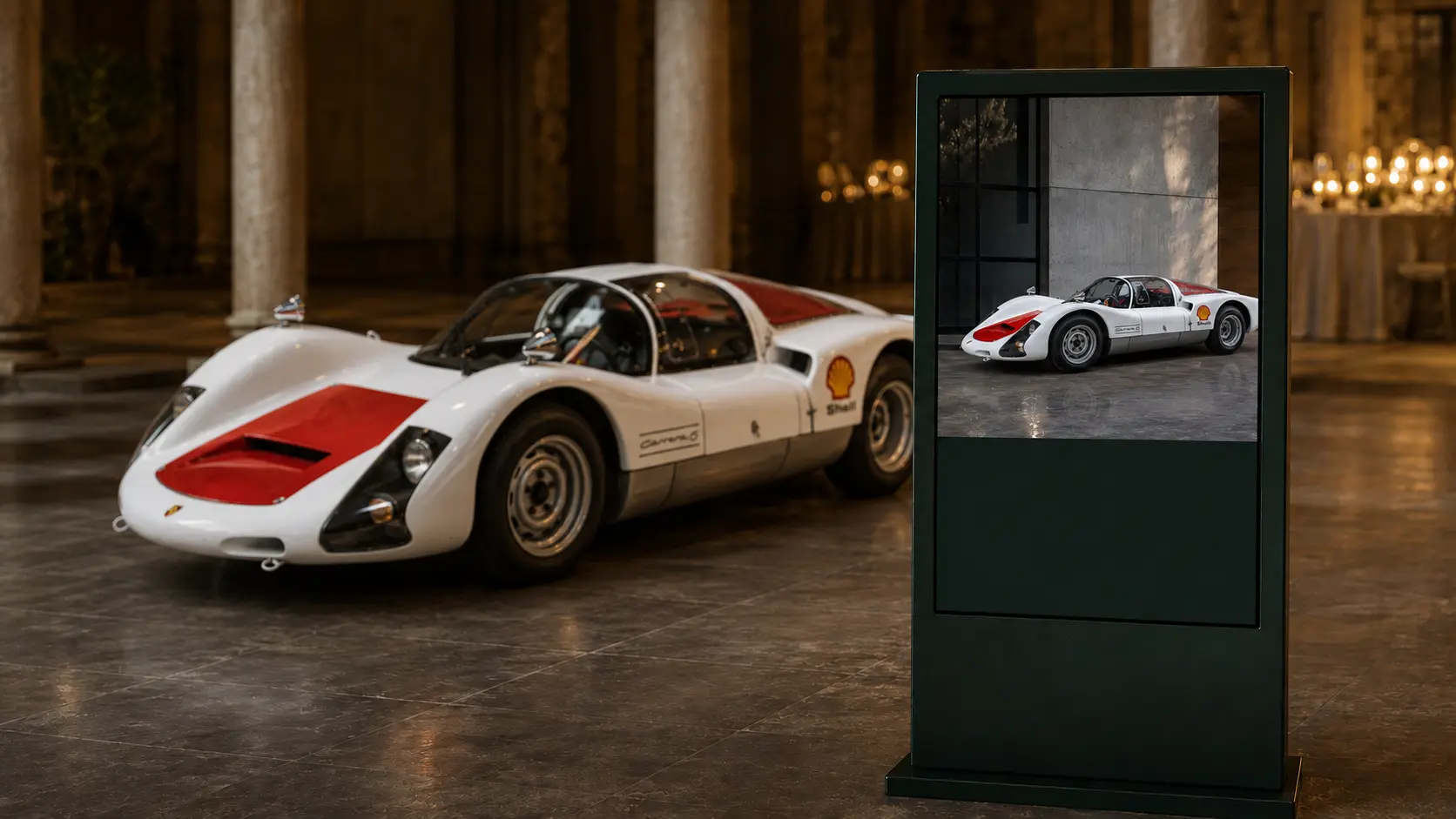 Living digital car dossier presented beside a competition Porsche
